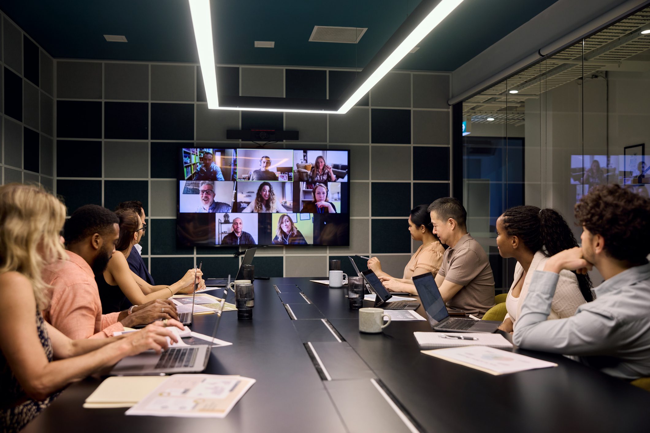 Colleagues video conferencing in a modern meeting room.