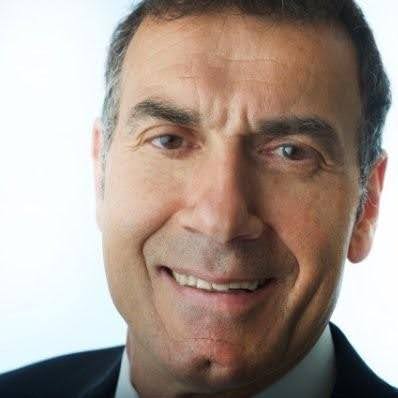 Close-up of a smiling middle-aged man in a suit.