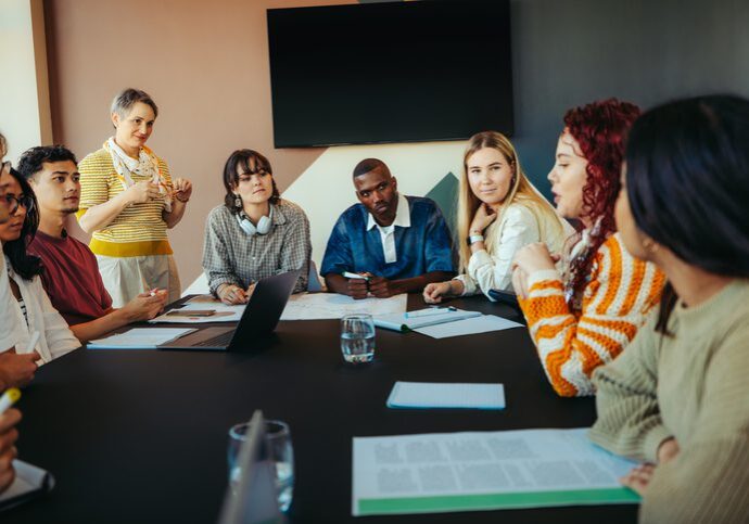 Team discussing ideas during a meeting around a conference table.